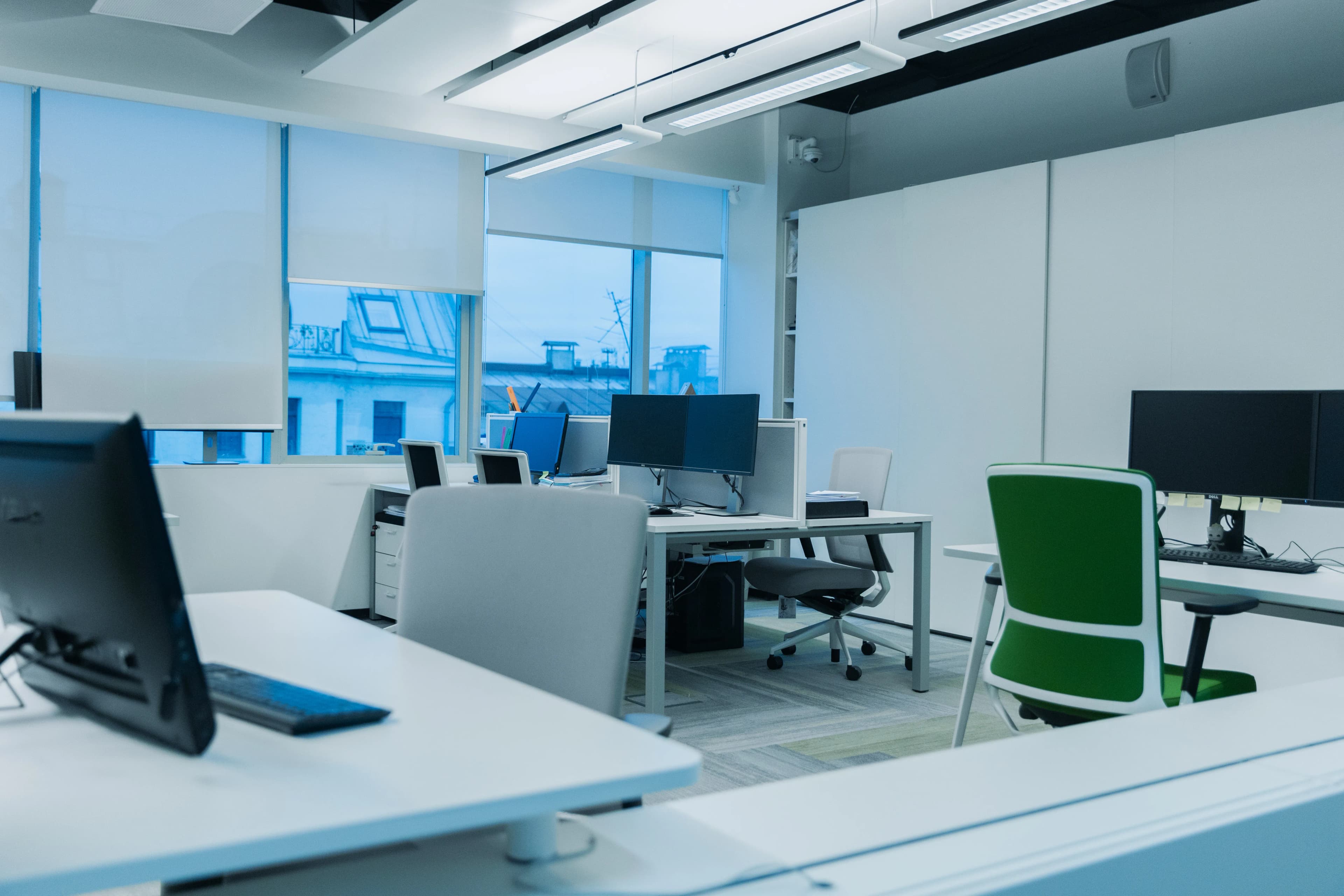 Geniş pencereli, bilgisayarlı aydınlık bir ofis