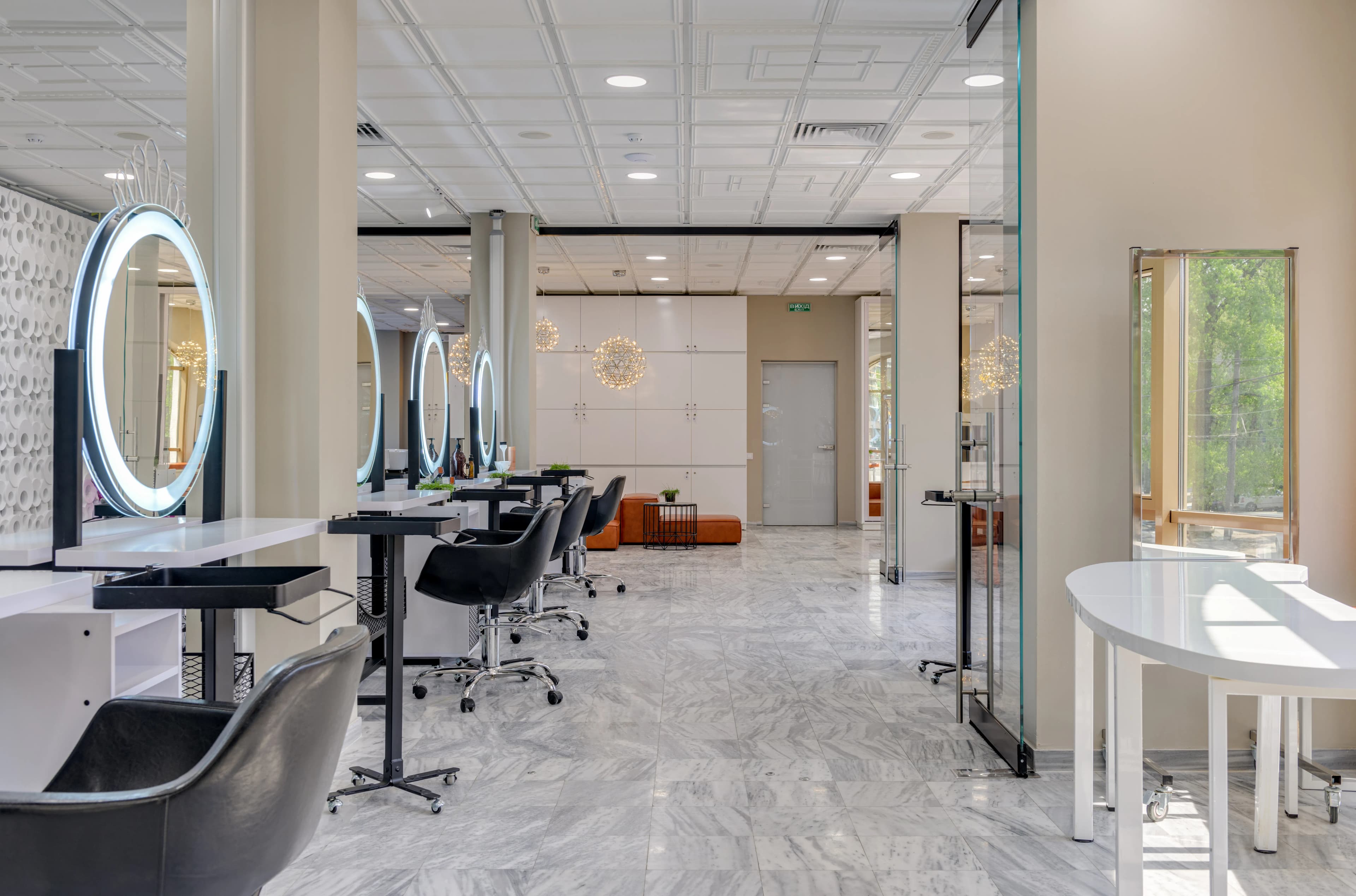 Aynaları ve koltuklarıyla geniş, modern bir güzellik salonu