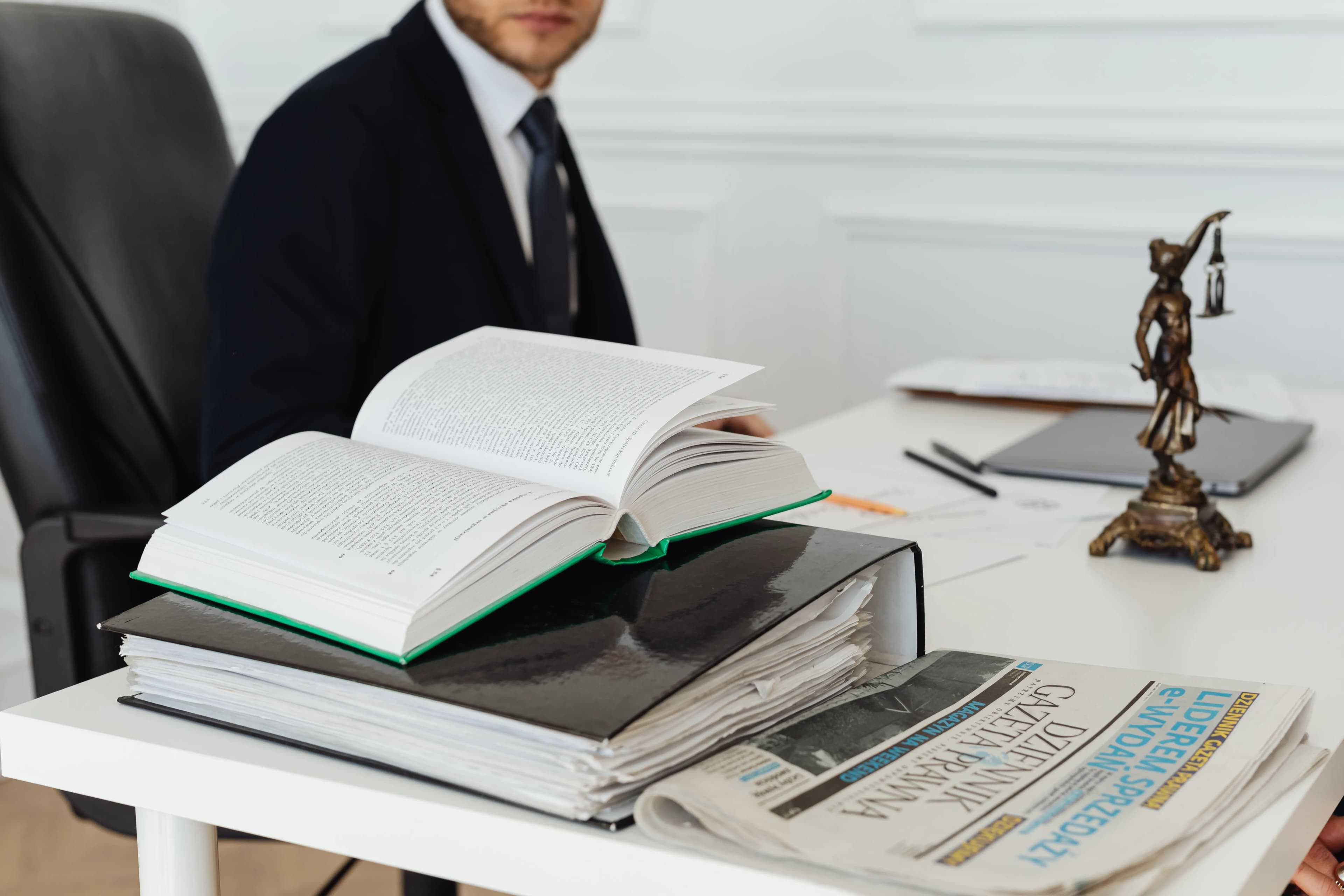 Hukuk kitapları, dosyalar ve gazetenin bulunduğu bir avukat masası
